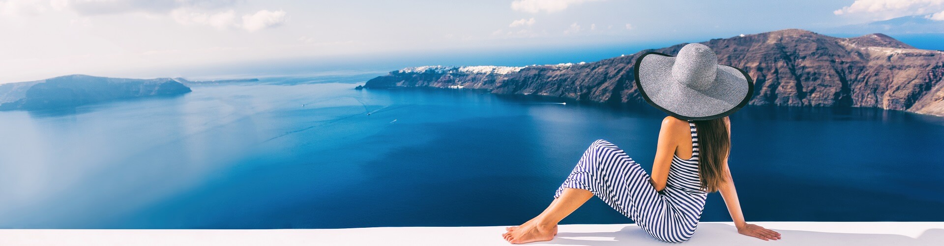 Travel luxury cruise vacation holiday woman panoramic banner. Sun hat maxi dress woman relaxing at sea view in Santorini, Oia, Greece. Europe destination.